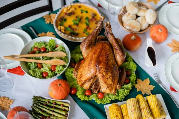 Erntedank-Dinner mit gebratenem Truthahn und frischem Gemüse in der Nähe von Kürbiskuchen und gegrilltem Mais — Stockfoto