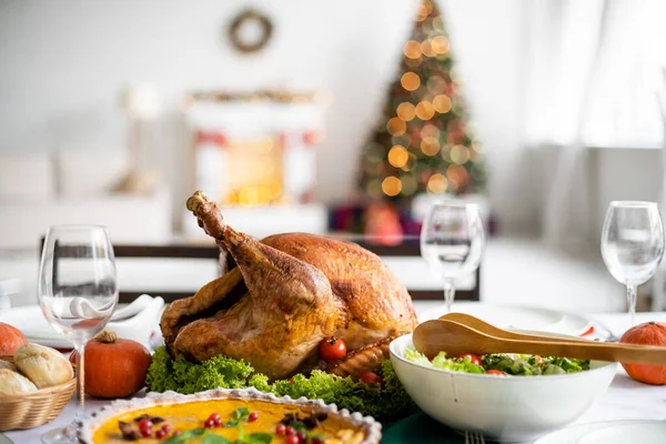 Torta de abóbora e salada de legumes frescos perto de peru assado na mesa com jantar de ação de graças — Fotografia de Stock