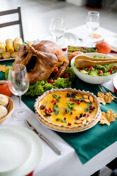 Delicious roasted turkey near traditional pumpkin pie with cranberries and mint leaves served for thanksgiving dinner — Stock Photo