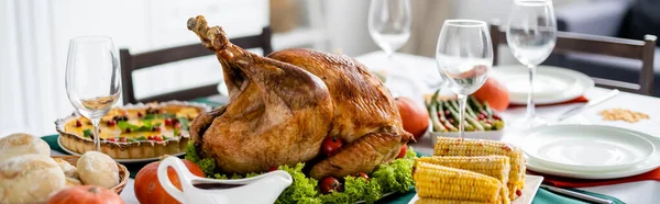 Köstlich gebratener Truthahn in der Nähe von gegrilltem Mais und verschwommenem Kürbiskuchen auf dem Tisch mit Erntedankdinner, Banner — Stockfoto