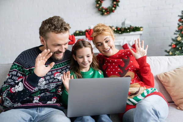 Cheerful family in sweaters having video call on laptop at home — Stock Photo