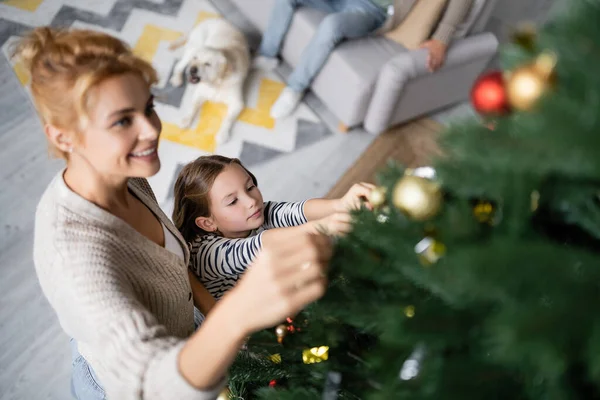 Vista de ângulo alto da menina decorando árvore de Natal com a mãe em casa — Fotografia de Stock