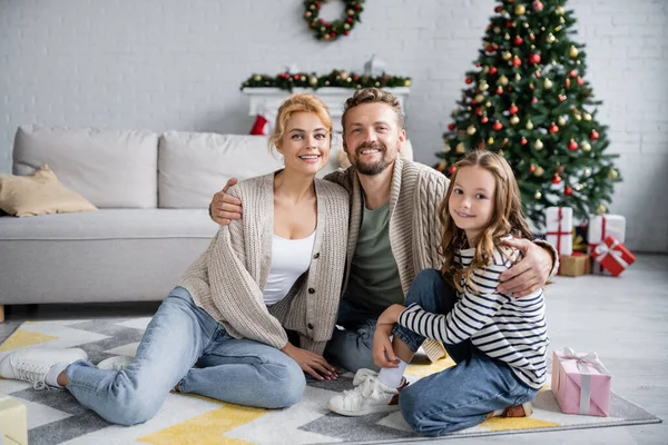 Uomo positivo abbracciare la famiglia durante la celebrazione del nuovo anno a casa — Foto stock