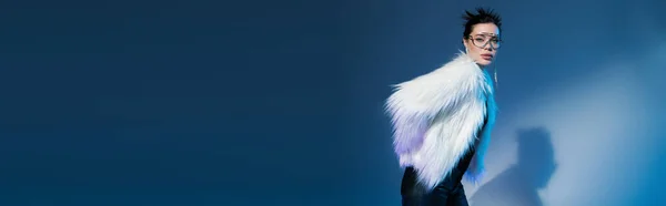 Mujer de moda en elegante chaqueta de piel sintética y gafas de sol transparentes sobre fondo azul con espacio para copiar, pancarta - foto de stock