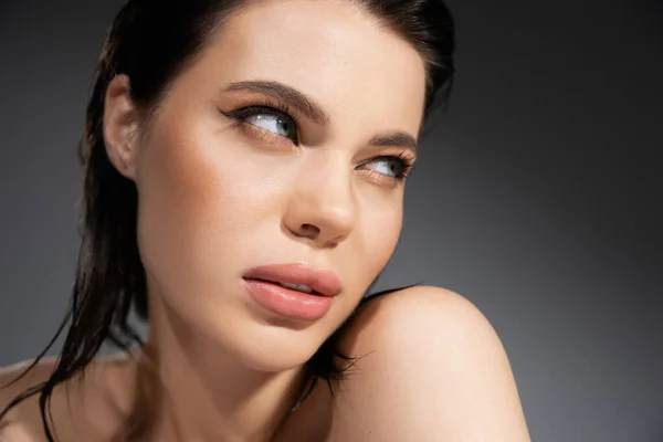 Young woman with naked shoulders looking away isolated on grey — Stock Photo