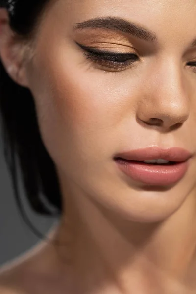 Vista recortada de una joven morena con rostro aislado en gris - foto de stock