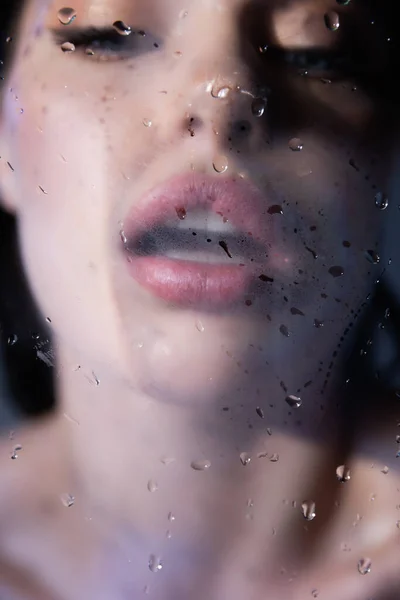 Femme floue respirant sur verre mouillé sur fond gris — Photo de stock