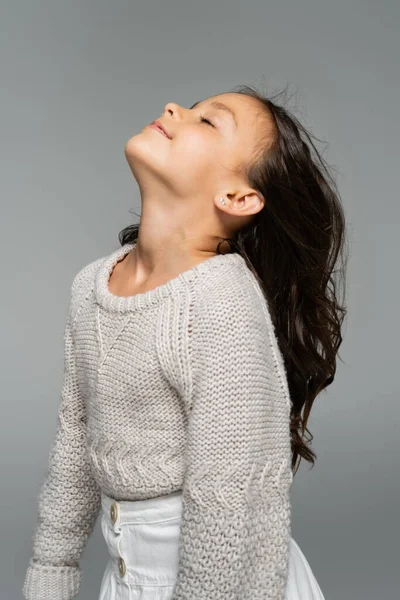 Chica morena en suéter de punto posando con la cabeza levantada aislada en gris - foto de stock