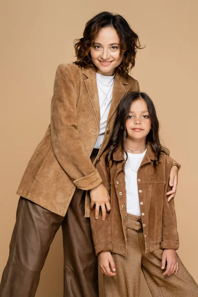 Mother and daughter in stylish autumn outfit smiling at camera isolated on beige — Stock Photo