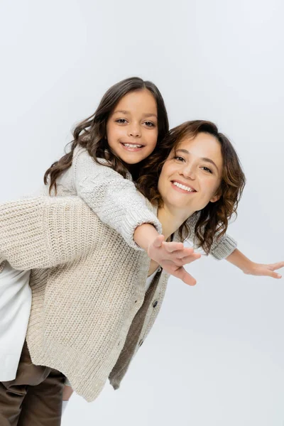 Sorrindo mulher brincando com a filha alegre enquanto piggybacking ela isolado em cinza — Fotografia de Stock