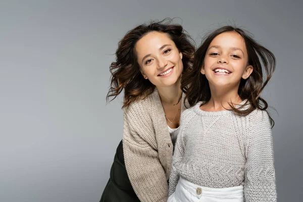 Animado mulher e menina na moda outono malhas sorrindo para a câmera isolada no cinza — Fotografia de Stock