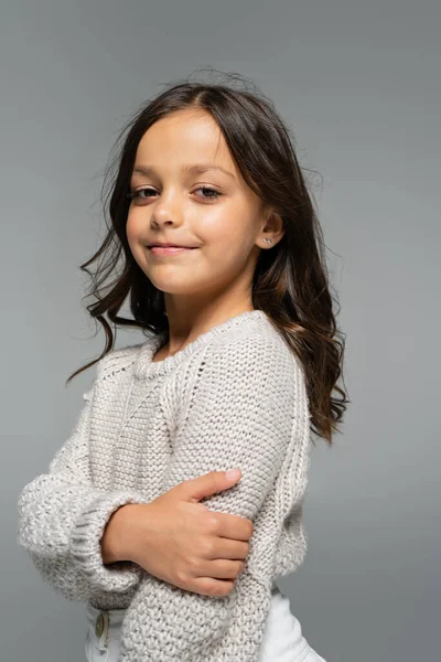 Брюнетка дівчина в теплий осінній светр посміхається на камеру ізольовано на сірому — стокове фото