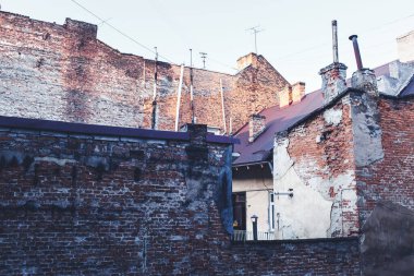 Eski, yıpranmış tuğla ev. Tuğla duvar yıkılıyor. Yoksulluk kavramı.