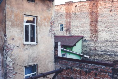 Yüksek tuğlalı duvarları olan bir avlu. Eski tuğla evler.