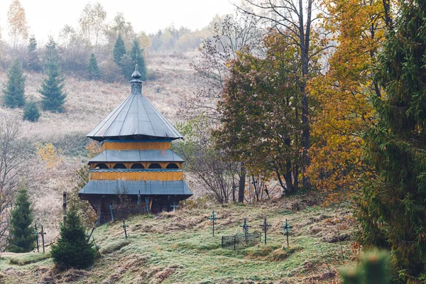 小さな木造教会と丘の上の墓地 — ストック写真