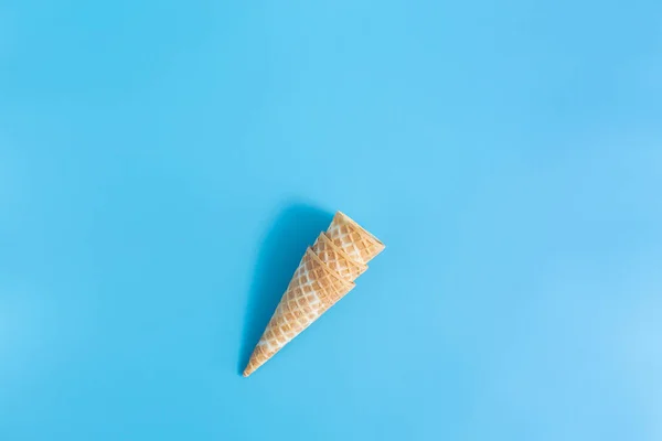 Three sweet crunchy empty ice cream wafer cups on a blue background — Stock Photo, Image