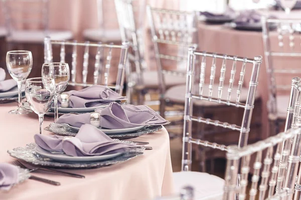 Hermosa mesa en el restaurante. Cubertería, sillas acrílicas transparentes, servilletas púrpuras — Foto de Stock