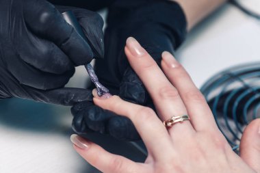 Tırnağında sim olan jel süsü sürüyorum.