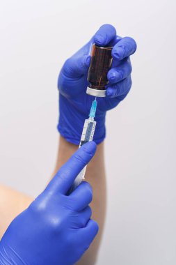 Covid 19 vaccine bottle and syringe in the hand of a gloved researcher