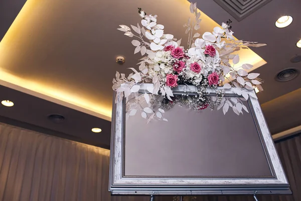 Mirrored easel decorated with flowers in a restaurant. Place for your layout. copy space — Stock Photo, Image