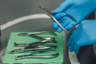 orthodontist holds pliers for loops for braces