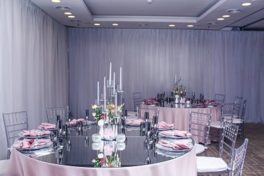 Bir restoranda ziyafet için dekore edilmiş elit ayna masaları.