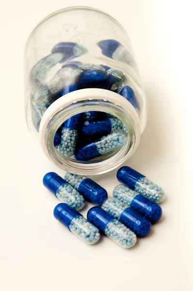 Blue pills spill out of the box — Stock Photo, Image