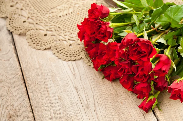 Piękne czerwone róże na drewnianym stołem — Zdjęcie stockowe