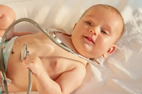Bebê brincando com um estetoscópio — Fotografia de Stock