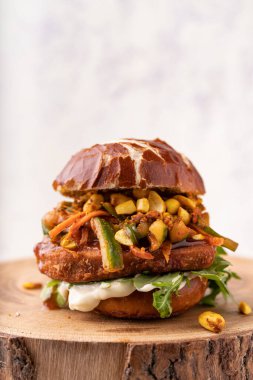 Etsiz nohut burger, havuç, kabak, mayonez, fıstık ezmesi ve yeşil roket yapraklı Asya füzyonlu yumuşak çörek.