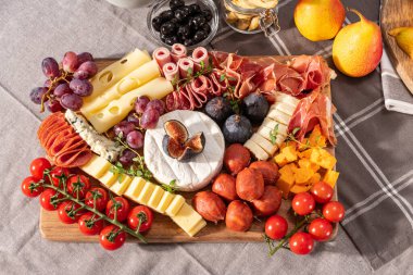 Tedavi edilmiş peynir ve meze tabağı çeşitli meyve, peynir, et ve kraker çeşitleri bakımından zengindir