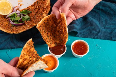 Geleneksel Akdeniz Fas pizzası üzerine kırmızı mercimek ve sosla servis edilen otlar.