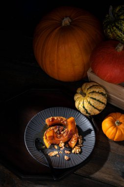 Sonbaharda kavrulmuş tereyağlı balkabağı, tarçın, ceviz ve bal tozuyla kaplanmış karamsar resimli natürmort.