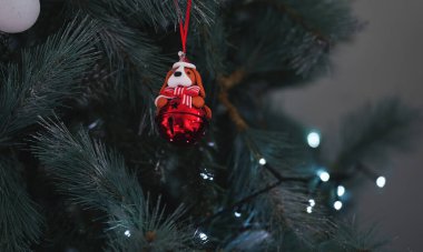 Noel ağacında asılı kırmızı kurdeleli bir köpeğin yer aldığı Noel süslemesi