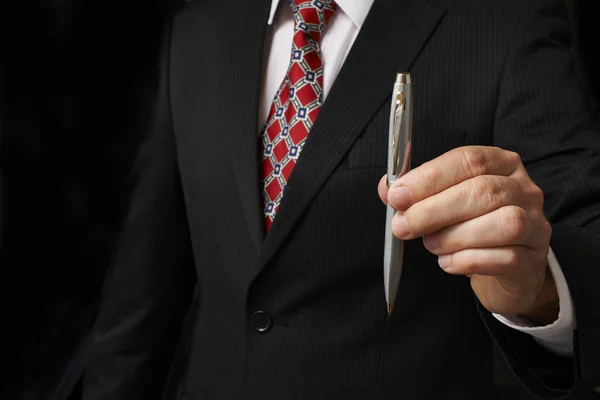 Businessman holding pen — Stock Photo, Image