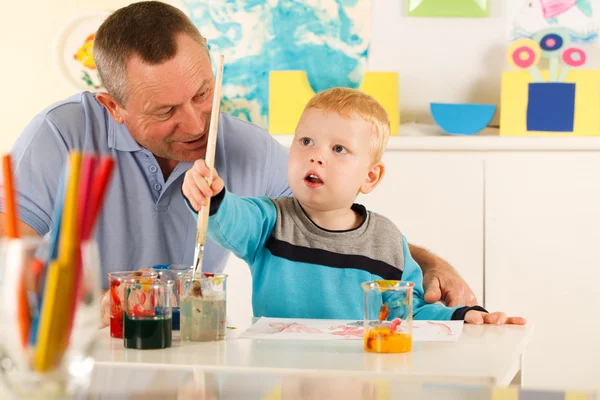 Kind malt mit einem Lächeln im Gesicht — Stockfoto