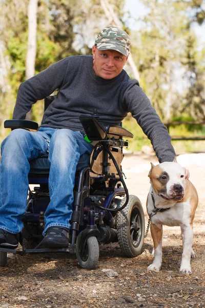 Jovem numa cadeira de rodas com o seu cão fiel  . — Fotografia de Stock