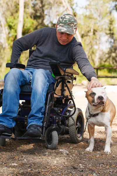 Joven en silla de ruedas con su fiel perro  . — Foto de Stock