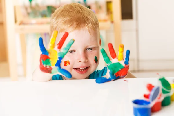 Criança feliz com as mãos pintadas — Fotografia de Stock