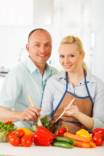 Couple in the kitchen preparing salad — Stock Photo, Image