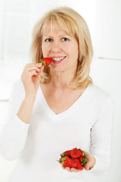 Frau isst Erdbeeren — Stockfoto