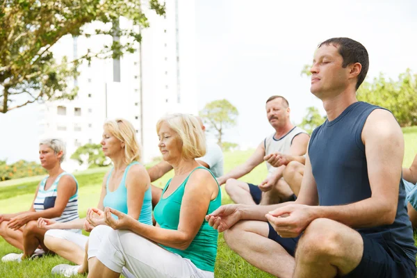Äldre personer med yoga tränare — Stockfoto