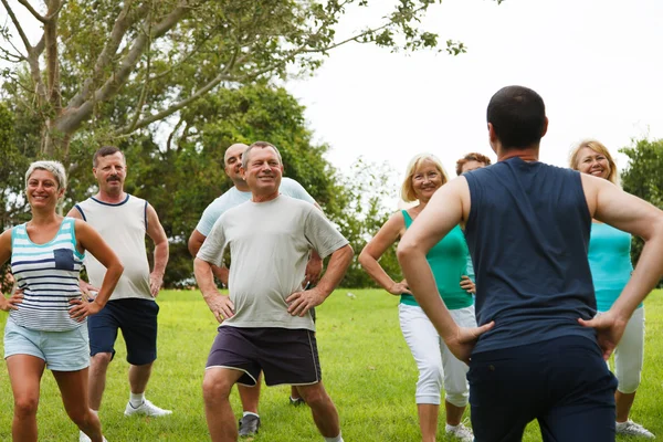 Aktiva äldre människor med tränare — Stockfoto