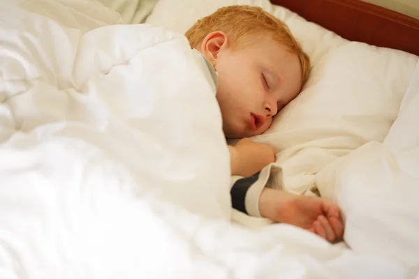 Ung pojke sova i sängen — Stockfoto