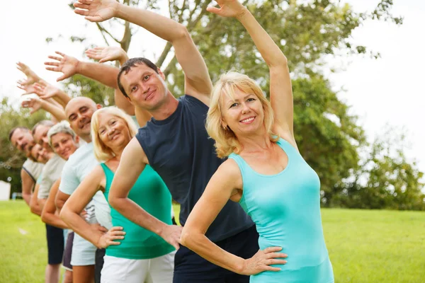 Mensen doen flexibiliteit exercises.focus op voorgrond. — Stockfoto