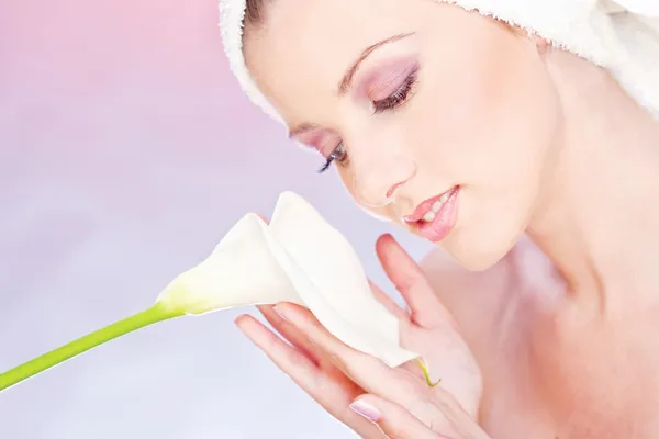 Pretty woman with towel gently holding a white flower — Stock Photo, Image