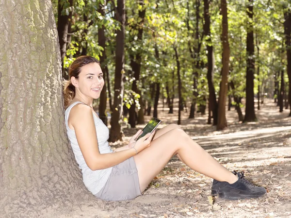 Meisje in park met tablet pc — Stockfoto