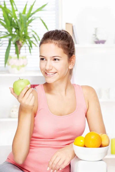 Femme heureuse à la maison avec des fruits — Photo