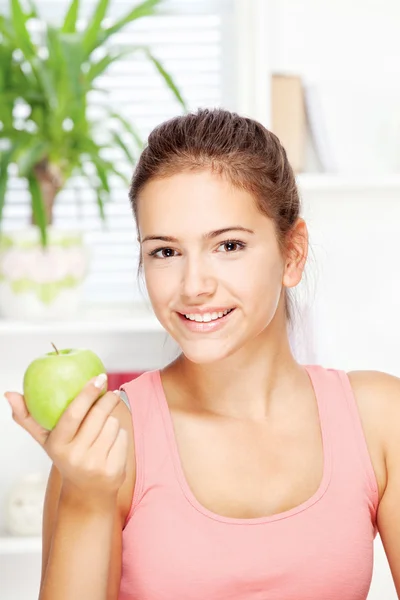 Femme heureuse à la maison avec des fruits — Photo