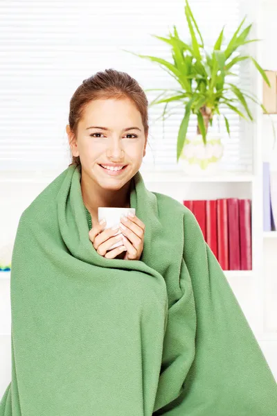 Femme buvant du thé à la maison couverte d'une couverture — Photo